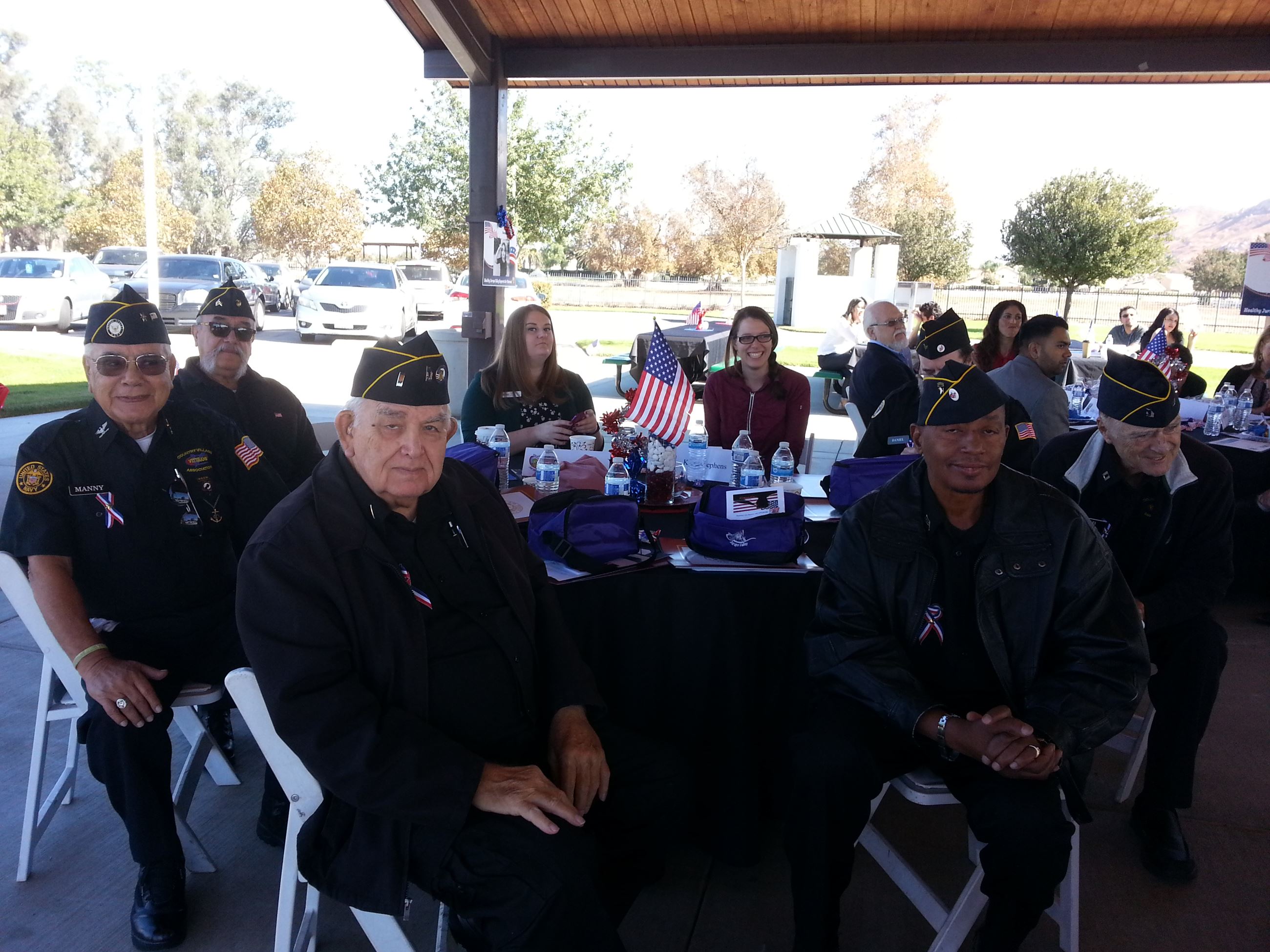Group of Elderly Veterans Sitting at Table Together at Celebrating Veterans Event